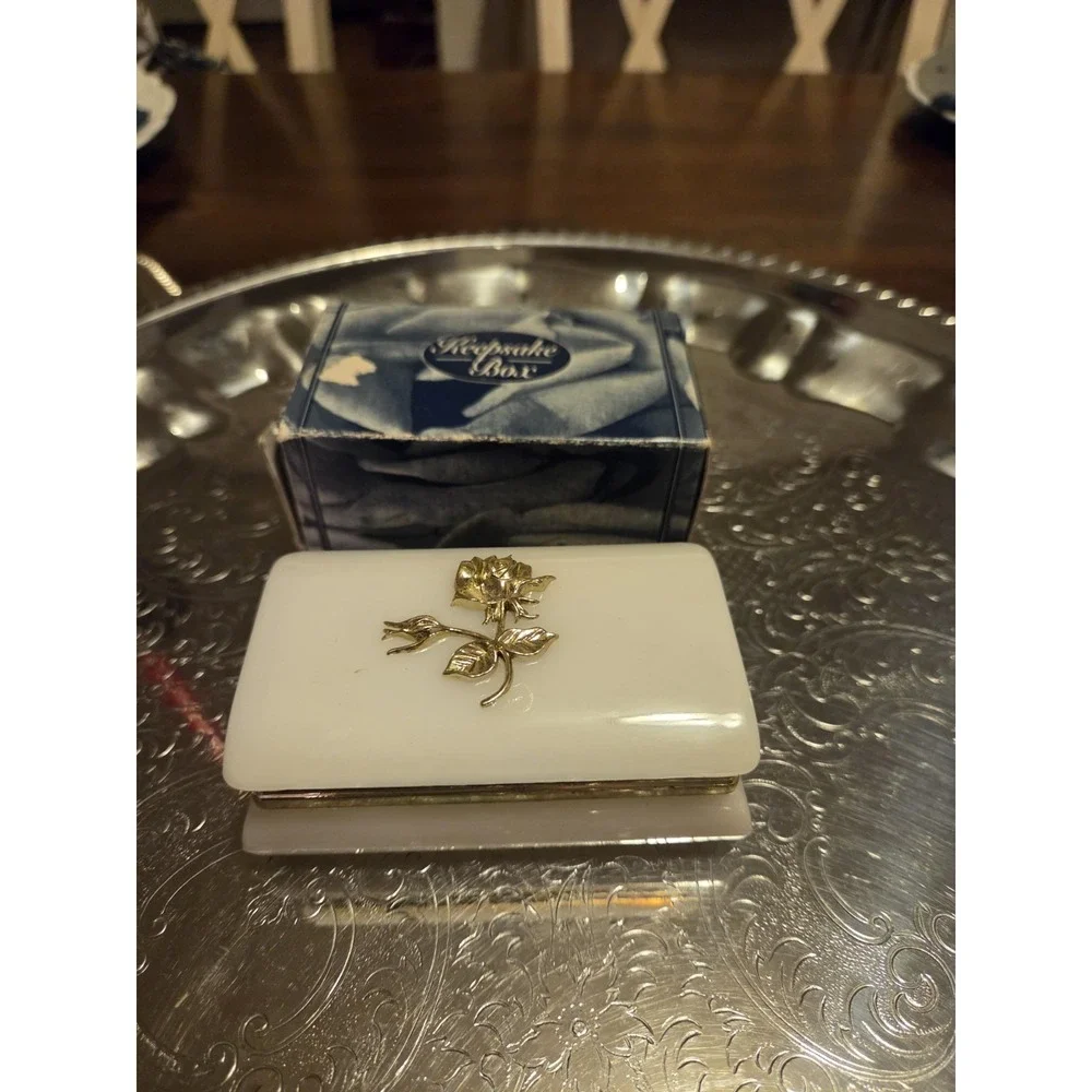 vintage white hinged trinket box features a polished finish with a delicate,...